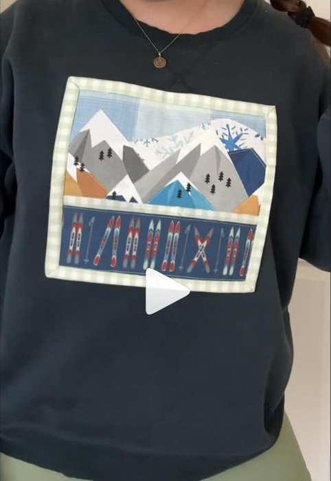 Mountain scene pieced from scrap fabric and appliqued onto a crewneck